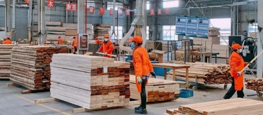 Workers in China handling lumber.